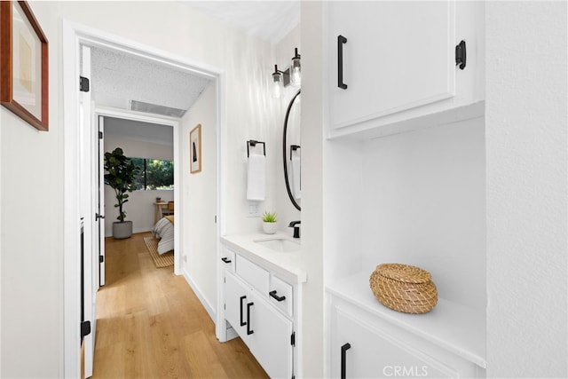 bathroom with vanity, hardwood / wood-style floors, and a textured ceiling