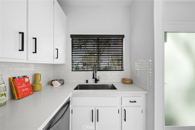 kitchen featuring white cabinetry, sink, backsplash, and dishwasher