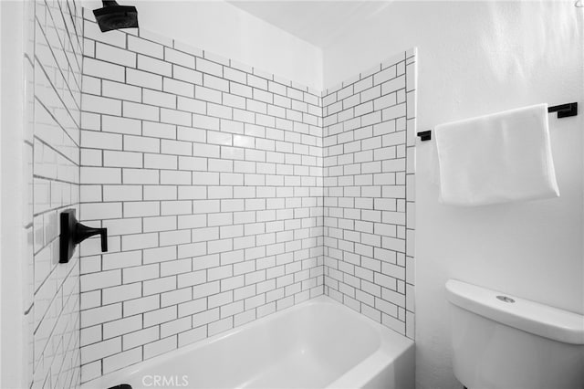 bathroom with tiled shower / bath combo and toilet