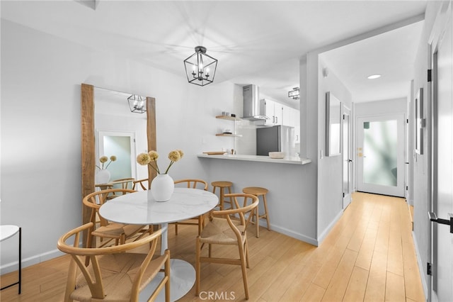 dining space with an inviting chandelier and light wood-type flooring