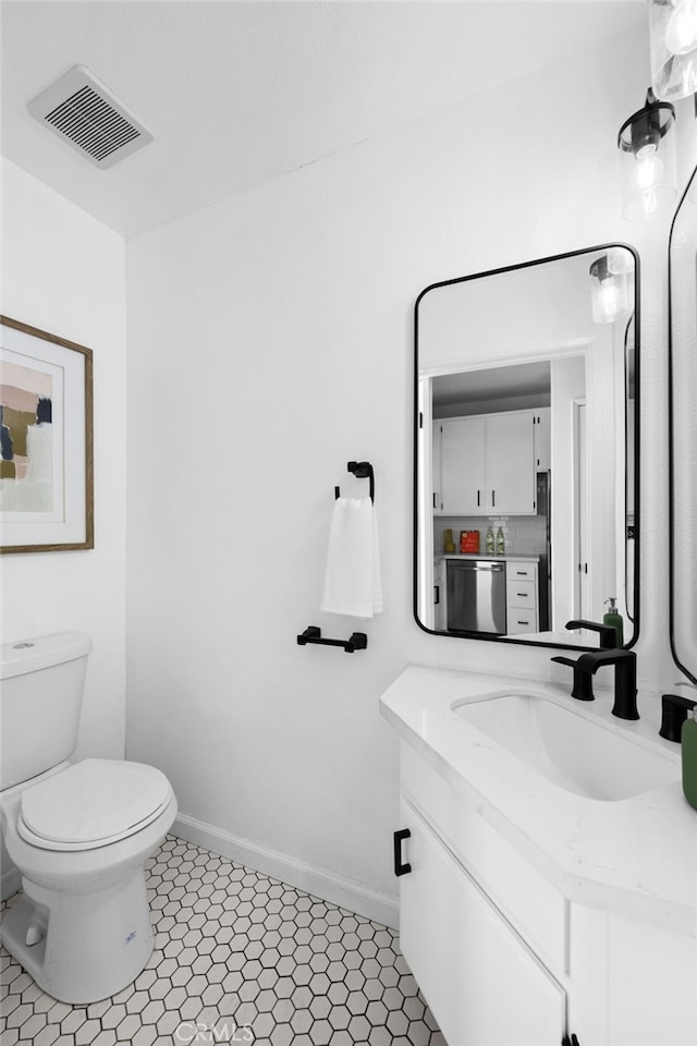 bathroom featuring vanity, tile patterned flooring, and toilet