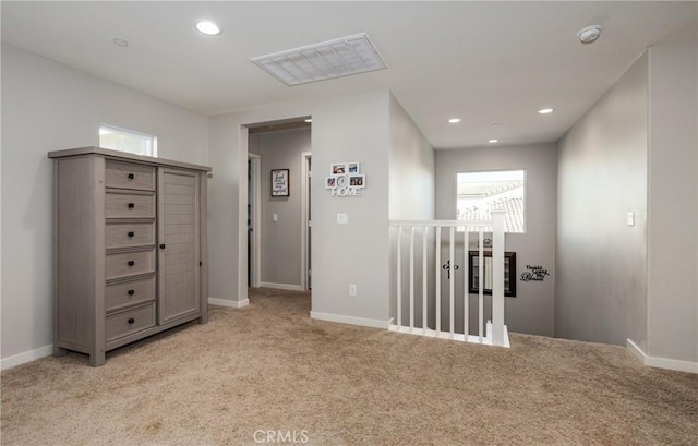 hallway with light carpet, visible vents, baseboards, an upstairs landing, and recessed lighting