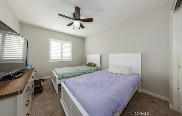 bedroom with a closet, ceiling fan, and dark colored carpet