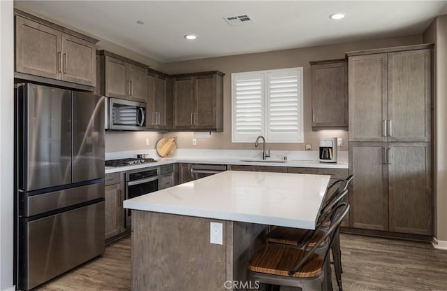 kitchen featuring dark wood finished floors, visible vents, stainless steel appliances, and a sink