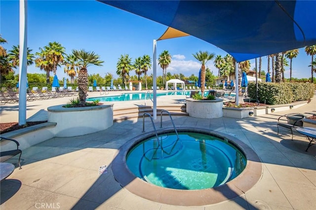 community pool with a community hot tub and a patio area