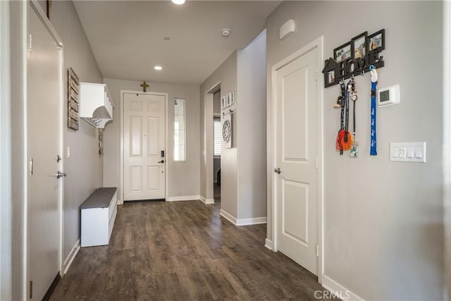 foyer entrance with dark wood-type flooring and baseboards