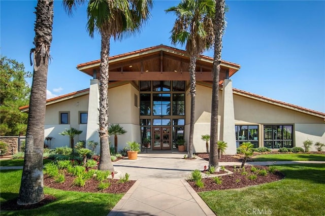 exterior space featuring french doors and a front lawn