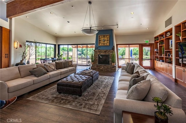 living area with high vaulted ceiling, a large fireplace, visible vents, and wood finished floors