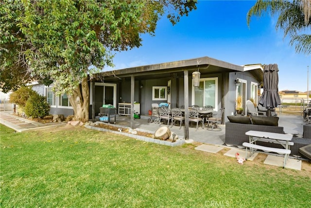 rear view of house with a lawn and a patio