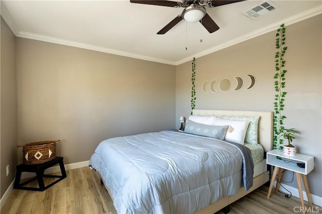 bedroom with light hardwood / wood-style flooring, ornamental molding, and ceiling fan