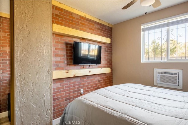 bedroom with a wall unit AC, ceiling fan, and brick wall