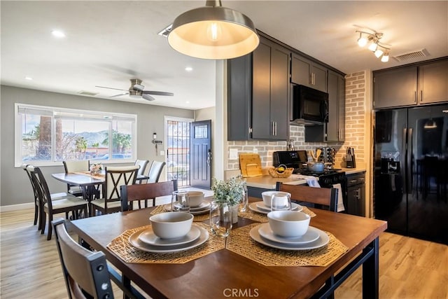 kitchen featuring tasteful backsplash, ceiling fan, light wood-type flooring, and black appliances