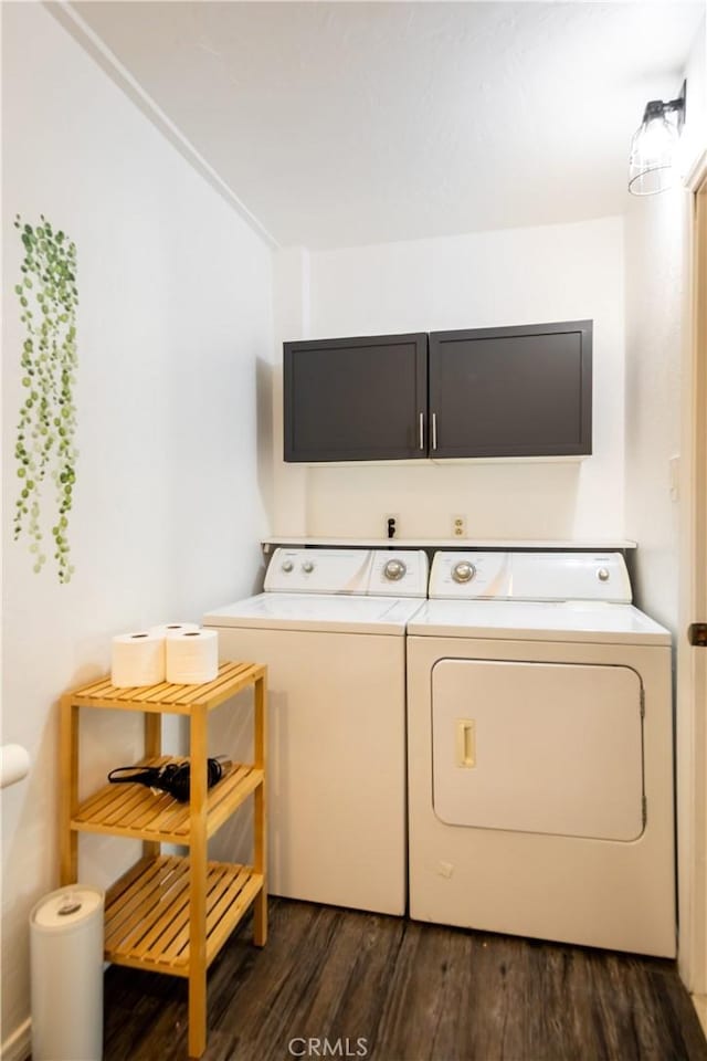 laundry area featuring dark wood-type flooring, cabinets, and washing machine and clothes dryer