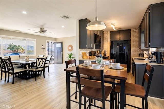 dining area with ceiling fan, sink, and light hardwood / wood-style flooring