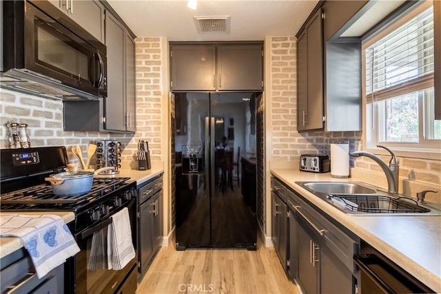 kitchen with tasteful backsplash, sink, light hardwood / wood-style flooring, and black appliances