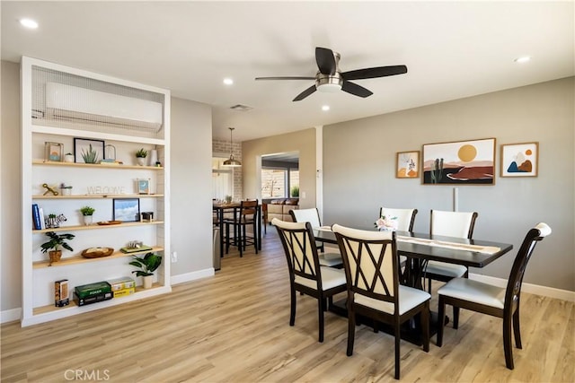 dining area featuring built in shelves, light hardwood / wood-style flooring, and ceiling fan