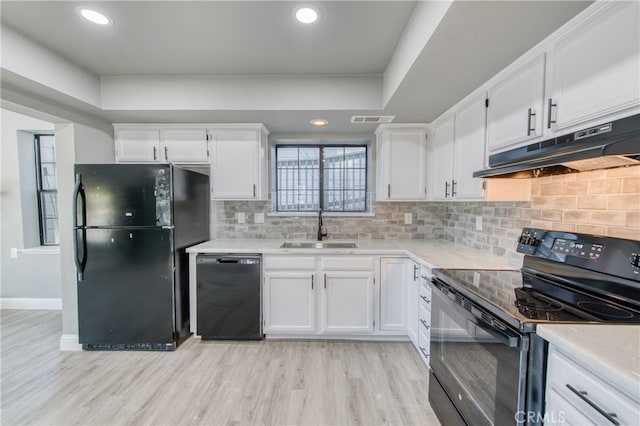 kitchen featuring tasteful backsplash, white cabinets, sink, and black appliances