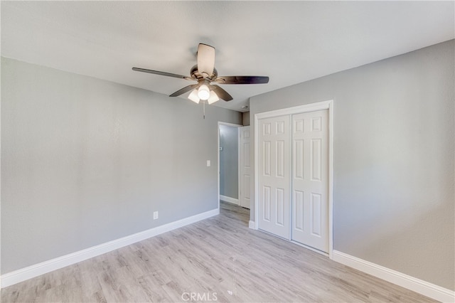 unfurnished bedroom with a closet, ceiling fan, and light wood-type flooring