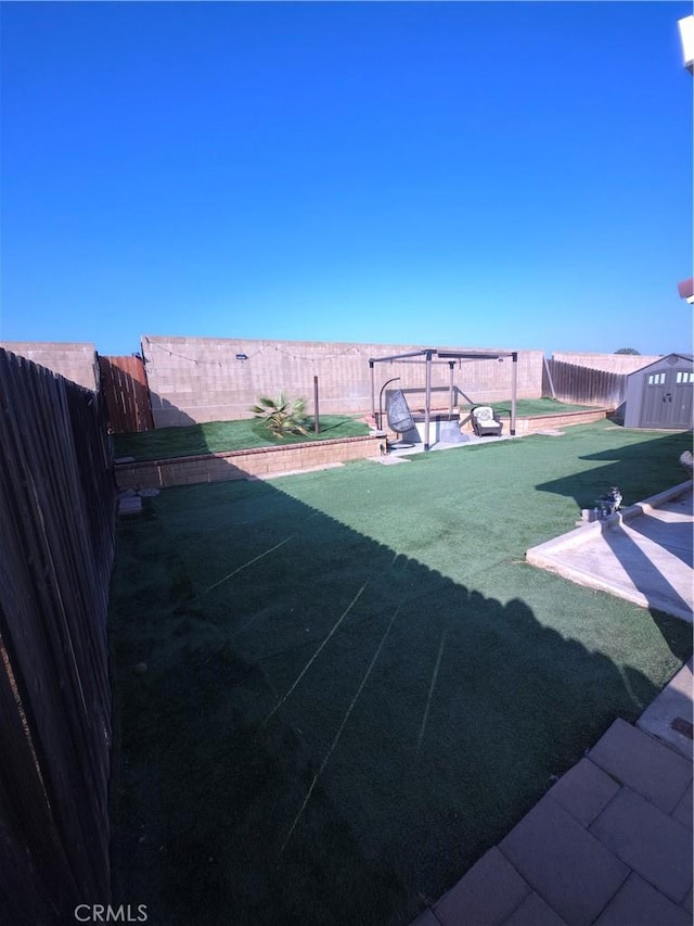 view of yard with a shed and a patio area