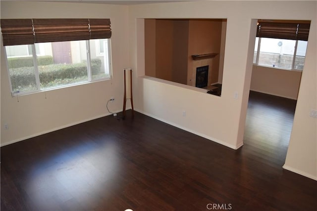 empty room featuring dark hardwood / wood-style flooring and a healthy amount of sunlight