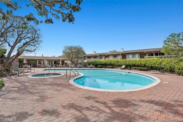 view of pool featuring a hot tub and a patio