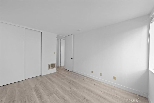 unfurnished bedroom featuring a closet and light wood-type flooring