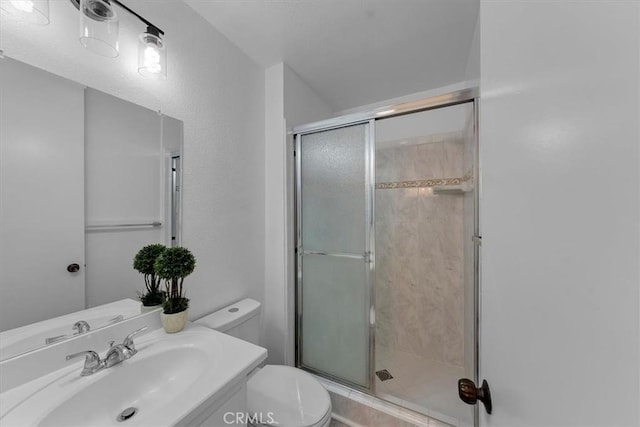 bathroom with vanity, toilet, and a shower with shower door