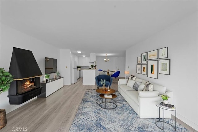 living room with a notable chandelier and light hardwood / wood-style floors