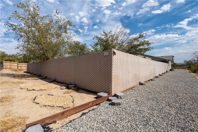 view of side of home featuring fence