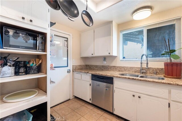 kitchen with sink, stainless steel dishwasher, white cabinets, and light tile patterned floors