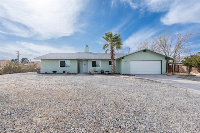 ranch-style home featuring an attached garage, fence, driveway, and stucco siding