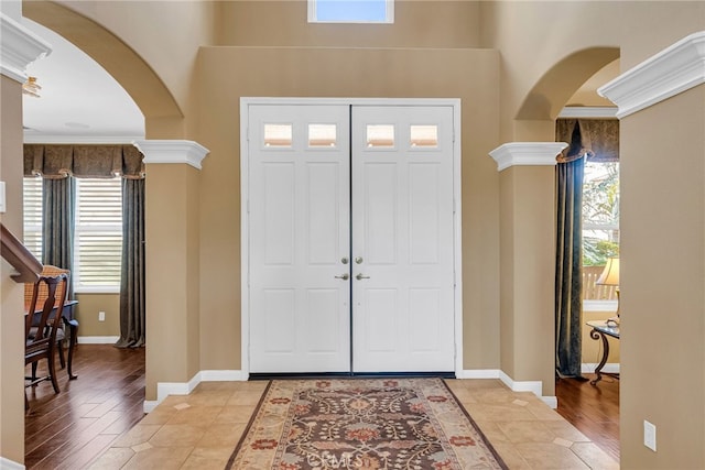 foyer featuring ornamental molding and light tile patterned flooring