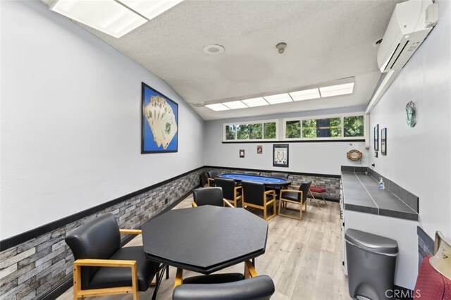 26478 Fairway Cir, Newhall, CA 91321 - rec room with an AC wall unit, a textured ceiling, and light wood finished floors