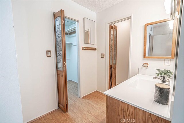 26478 Fairway Cir, Newhall, CA 91321 - bathroom with wood finished floors, vanity, and a textured ceiling