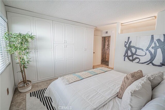 26478 Fairway Cir, Newhall, CA 91321 - bedroom with light colored carpet, a textured ceiling, and a closet