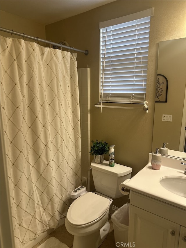 bathroom with vanity, curtained shower, and toilet