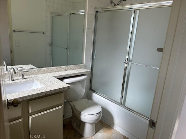 full bathroom featuring vanity, shower / bath combination with glass door, and toilet