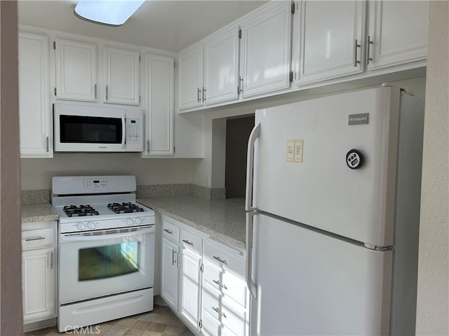 kitchen featuring light stone countertops, white cabinets, and white appliances