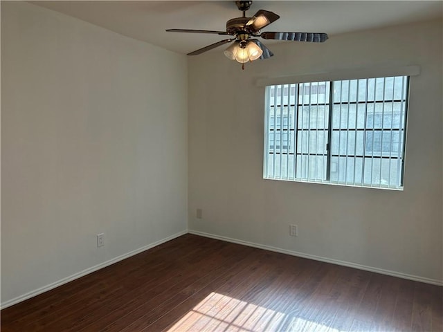 unfurnished room featuring a healthy amount of sunlight, dark wood-type flooring, and ceiling fan