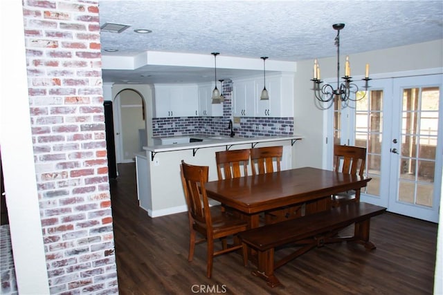 dining room with french doors, dark hardwood / wood-style floors, sink, and a textured ceiling