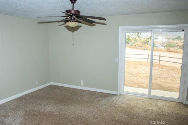 carpeted empty room featuring ceiling fan and a textured ceiling