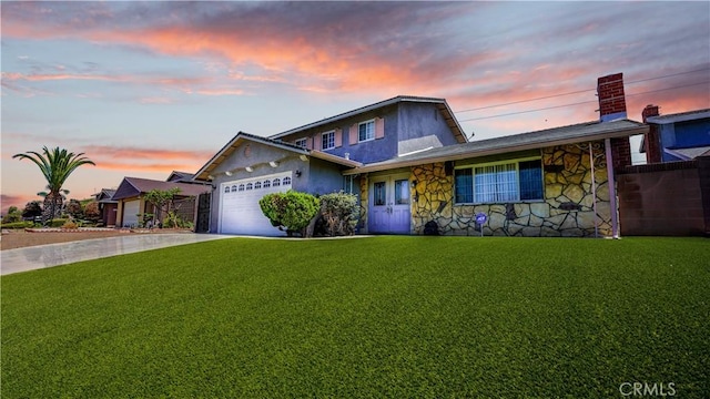 view of front facade with a yard and a garage