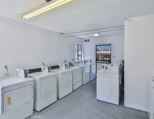 laundry room with washer and dryer and a textured ceiling