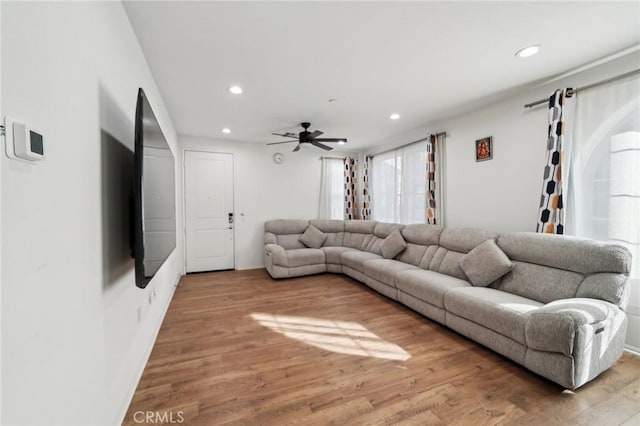 living room featuring wood-type flooring and ceiling fan