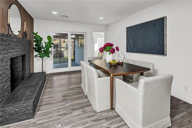 dining room featuring hardwood / wood-style floors and a fireplace