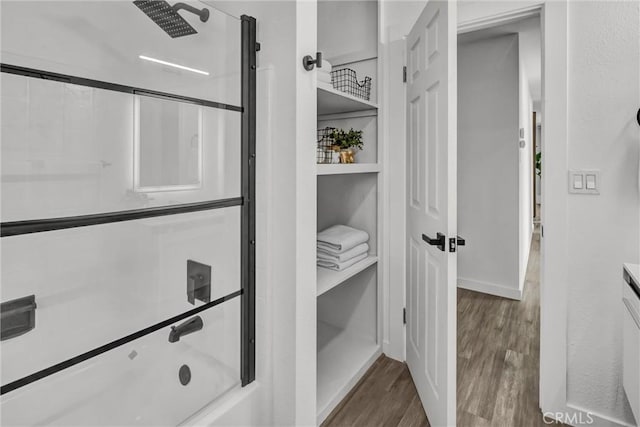 bathroom with enclosed tub / shower combo and hardwood / wood-style floors