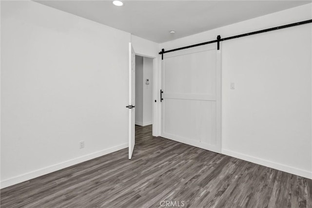 interior space featuring dark wood-type flooring and a barn door