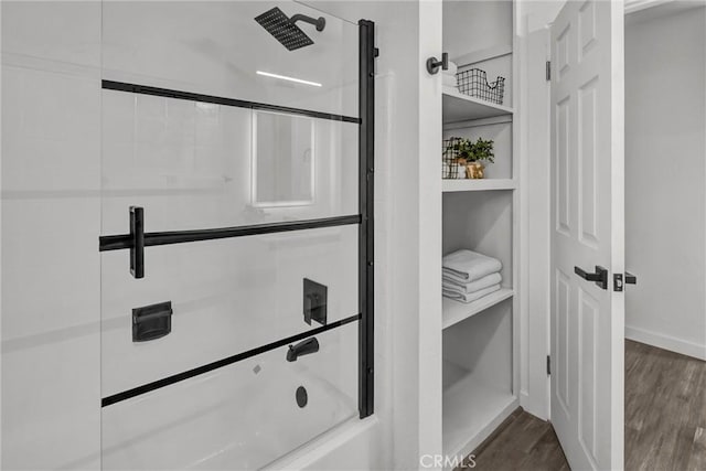 bathroom featuring wood-type flooring and combined bath / shower with glass door