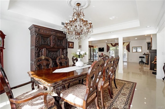 dining room featuring an inviting chandelier, crown molding, and a raised ceiling