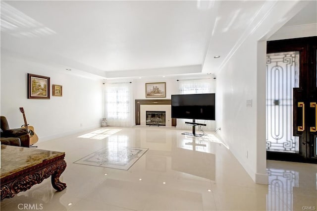 living room with light tile patterned floors and a tray ceiling